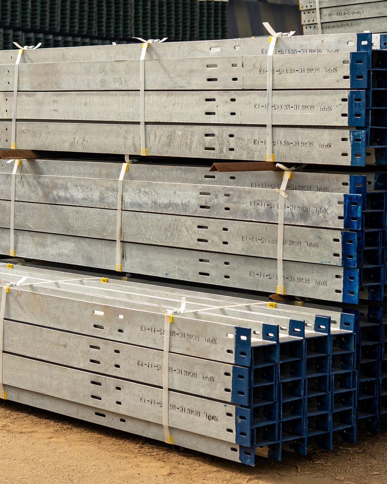 Galvanised steel beams strapped and stacked in a building materials supply yard