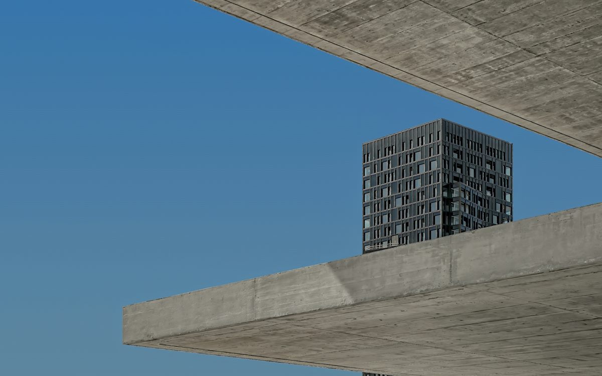 Cantilevered concrete slabs of a modern building under a blue sky